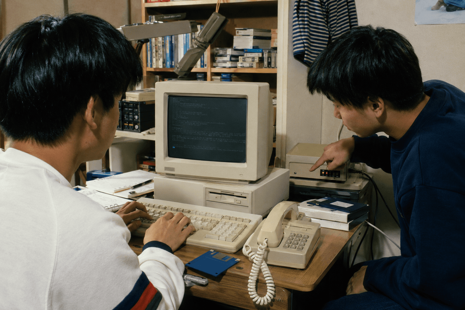 1990年代の子ども部屋で、若者がデスクトップパソコンとモデムを使い、電話回線をつないで接続作業をしている情景のイメージ画像(特定のサービス・画面の再現ではありません)