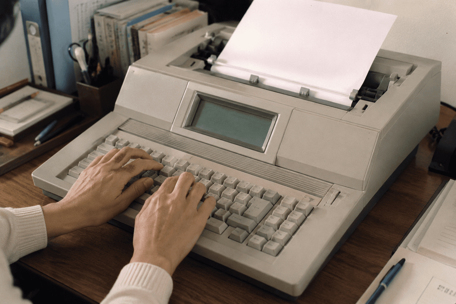 ワープロ専用機で文書を入力する手元のイメージ