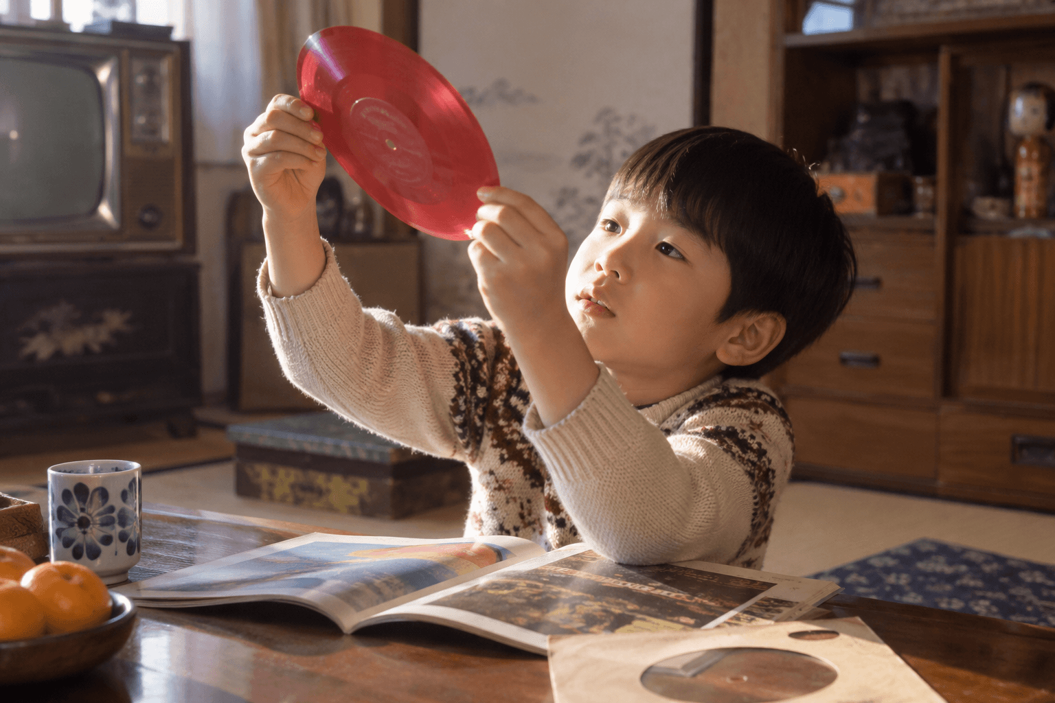 雑誌についていたソノシートを手に取る子どものイメージ