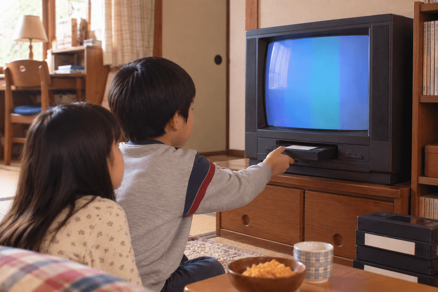 子供部屋に置かれたテレビデオでビデオを見る子どものイメージ