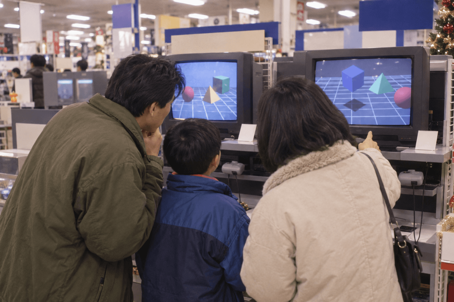 1990年代半ば、家電量販店で複数のテレビゲーム機の画面を見比べる家族の様子。実在のゲーム機の再現ではありません。